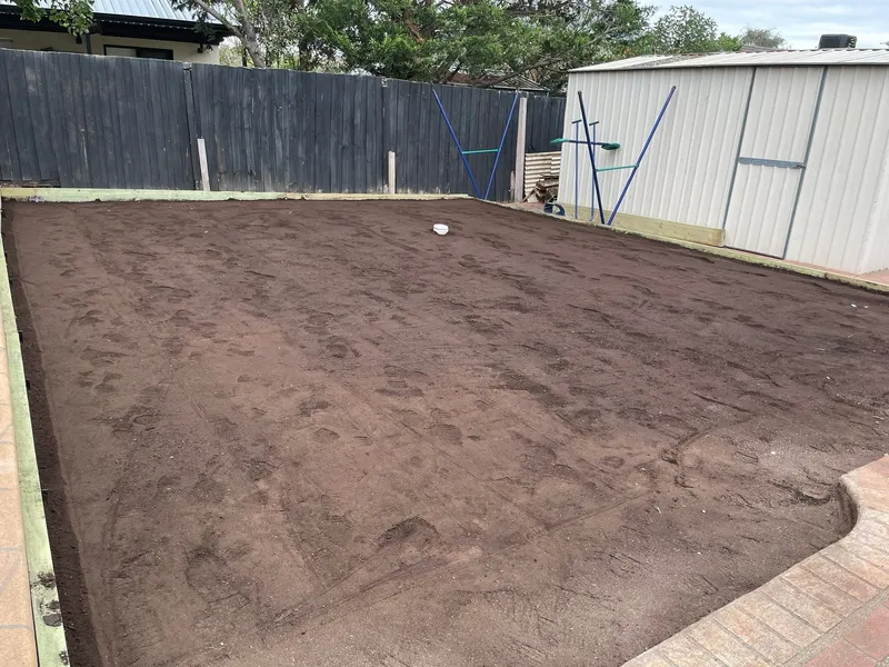 Rough, uneven ground around a new pool shell in a Sunbury backyard before earthworks.