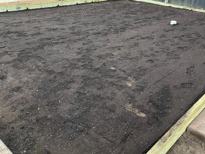 Skid-steer cutting the area back and setting levels around the pool surround.
